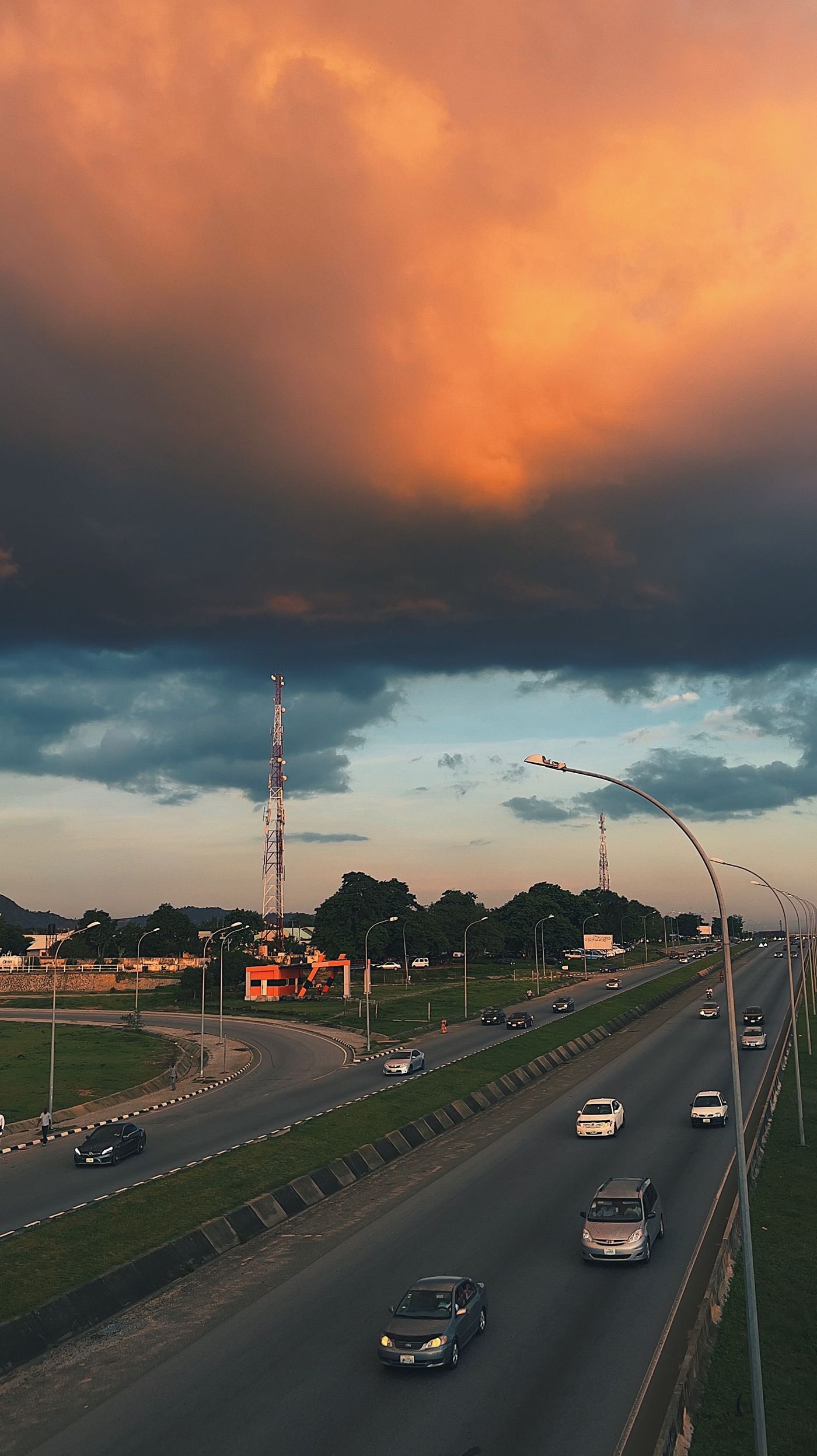 A Nigerian highway at sunset with traffic in motion
